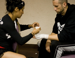 Coach Gina Reyes wraps Coach Dave Nielsen's hands pre fight for WCK World Championship Muay Thai at Hollywood Park Casino.
